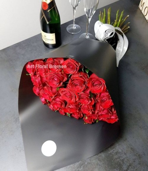 Romantischer Rosenstrauß in Rot mit stilvoller schwarzer Floristik-Verpackung