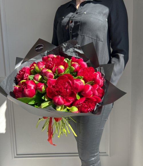 Luxus-Blumenarrangement mit dunklen Pfingstrosen und schwarzem Designpapier