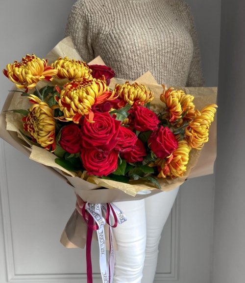 Blumenstrauß mit roten Rosen und großen gelben Chrysanthemen im warmen Farbstil