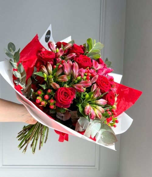 Handgebundener Blumenstrauß in Rot- und Rosatönen