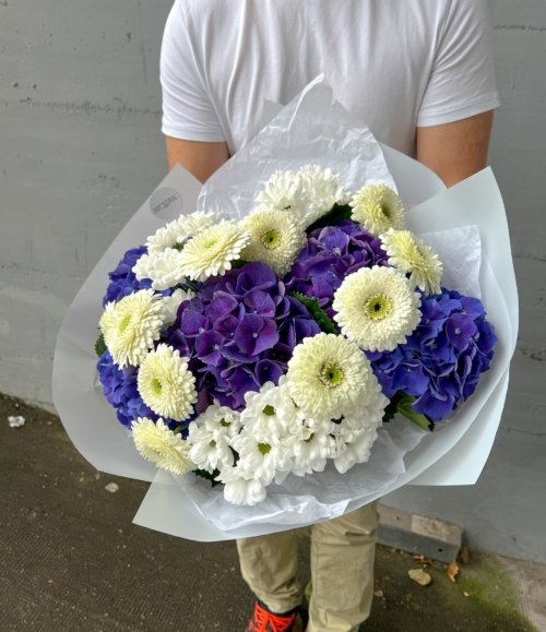 Moderner Blumenstrauß mit Hortensien in Blau und weißen Blüten als Geschenk
