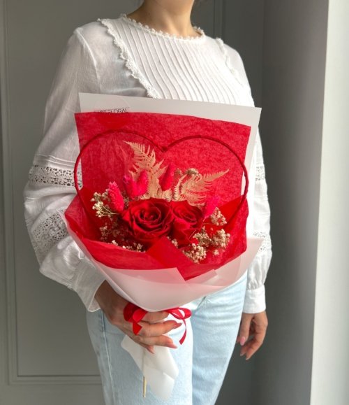 Detailaufnahme von konservierten roten Rosen im Arrangement