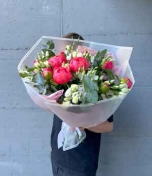 Frischer Pfingstrosenstrauß in Korallentönen mit weißen Lisianthus-Blüten und Eucalyptus-Grün