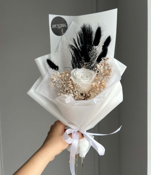 Trockenblumenstrauß mit rosa Rose, weißen und schwarzen Trockenblumen und schwarzem Federakzent