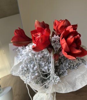 Winterstrauß mit Amaryllis und perlweißer Weihnachtsdekoration Nahaufnahme