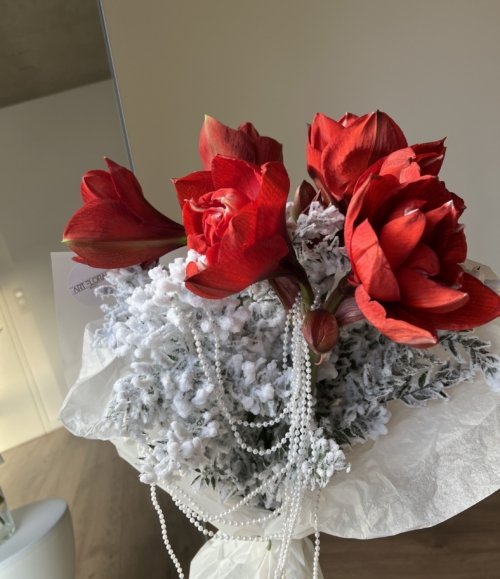 Winterstrauß mit Amaryllis und perlweißer Weihnachtsdekoration Nahaufnahme