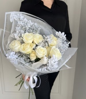 Eleganter Blumenstrauß im Winterstil mit weißen Rosen und dekorativem Schneevogel.