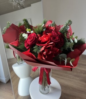 Weihnachtsstrauß in Rot mit Wintergrün und festlicher roter Verpackung Nahaufnahme