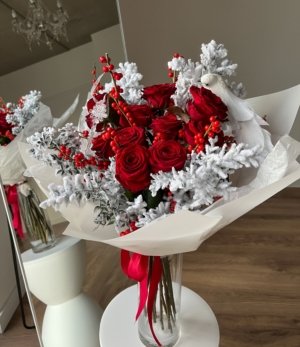 Wintermärchen Blumenstrauß mit roten Rosen und winterlichem Ruscus Nahaufnahme