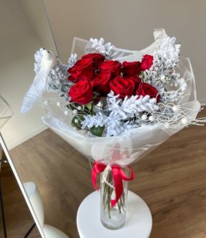 Blumenstrauß „Winterrose“ mit intensiven roten Rosen und winterlich weißem Ruscus für festliche Dekoration.