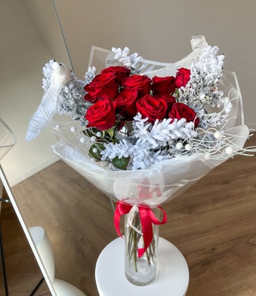 Blumenstrauß „Winterrose“ mit intensiven roten Rosen und winterlich weißem Ruscus für festliche Dekoration.