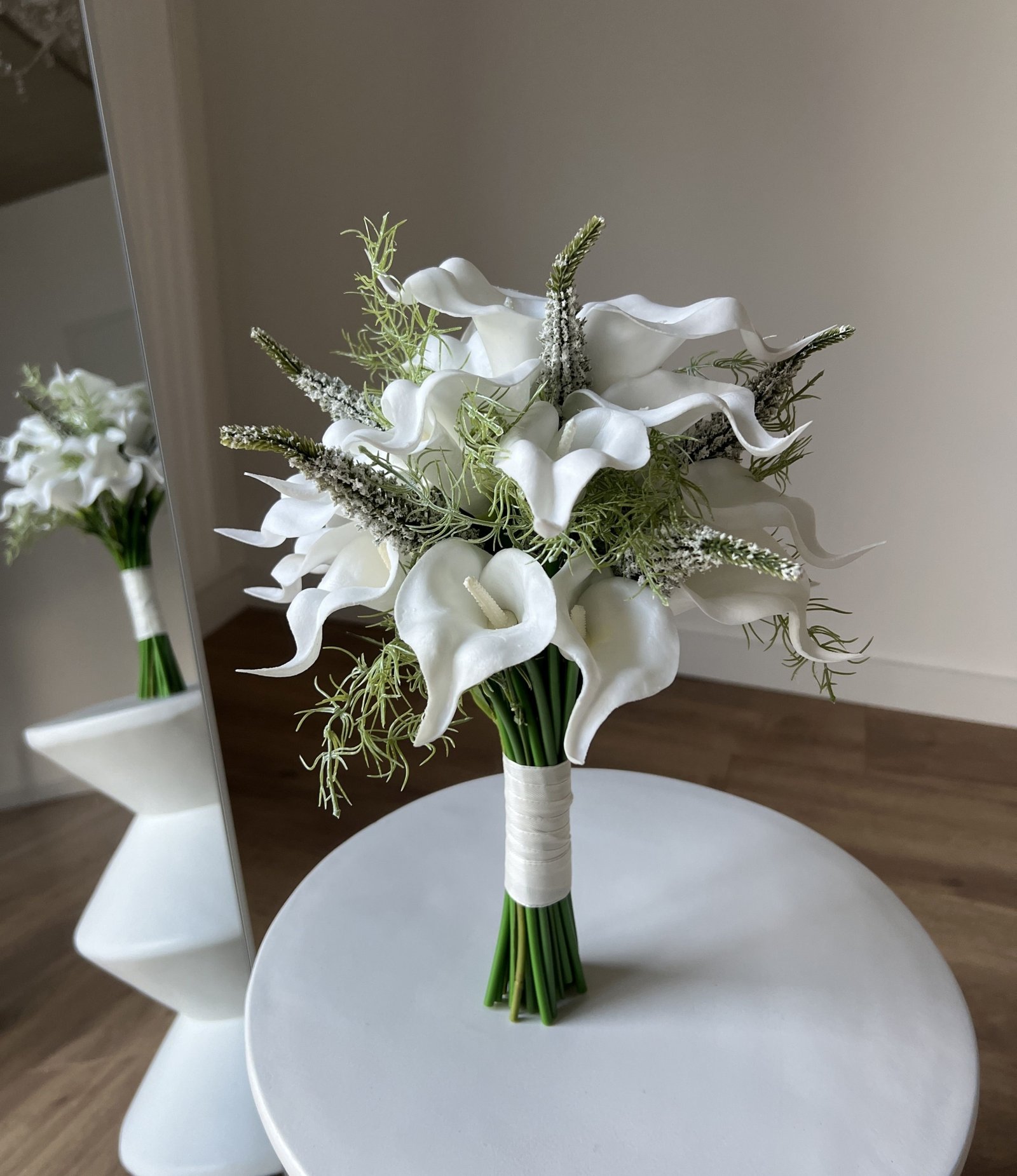 Blumenstrauß Bridal Calla mit weißen künstlichen Calla und grünen Blättern.