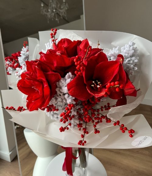 Winterlicher Strauß Roter Frost mit festlichen roten Amaryllis und grünen Ilexzweigen.
