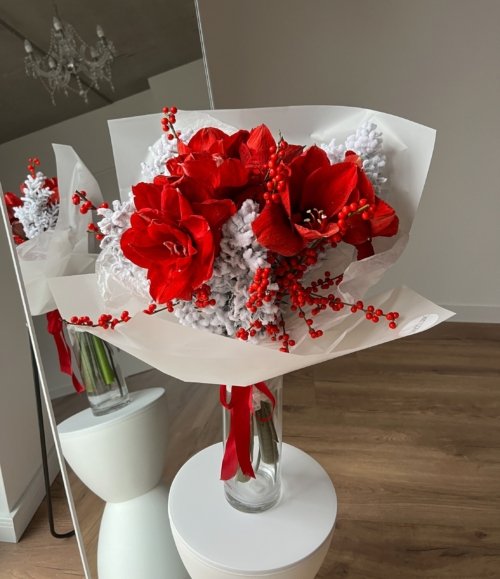 Roter Amaryllis-Strauß „Roter Frost“ kombiniert mit verschneiten Winterzweigen.
