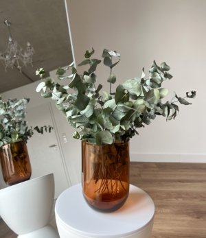 Braune Glasvase „Cognacglas“ mit Blumenarrangement dekoriert