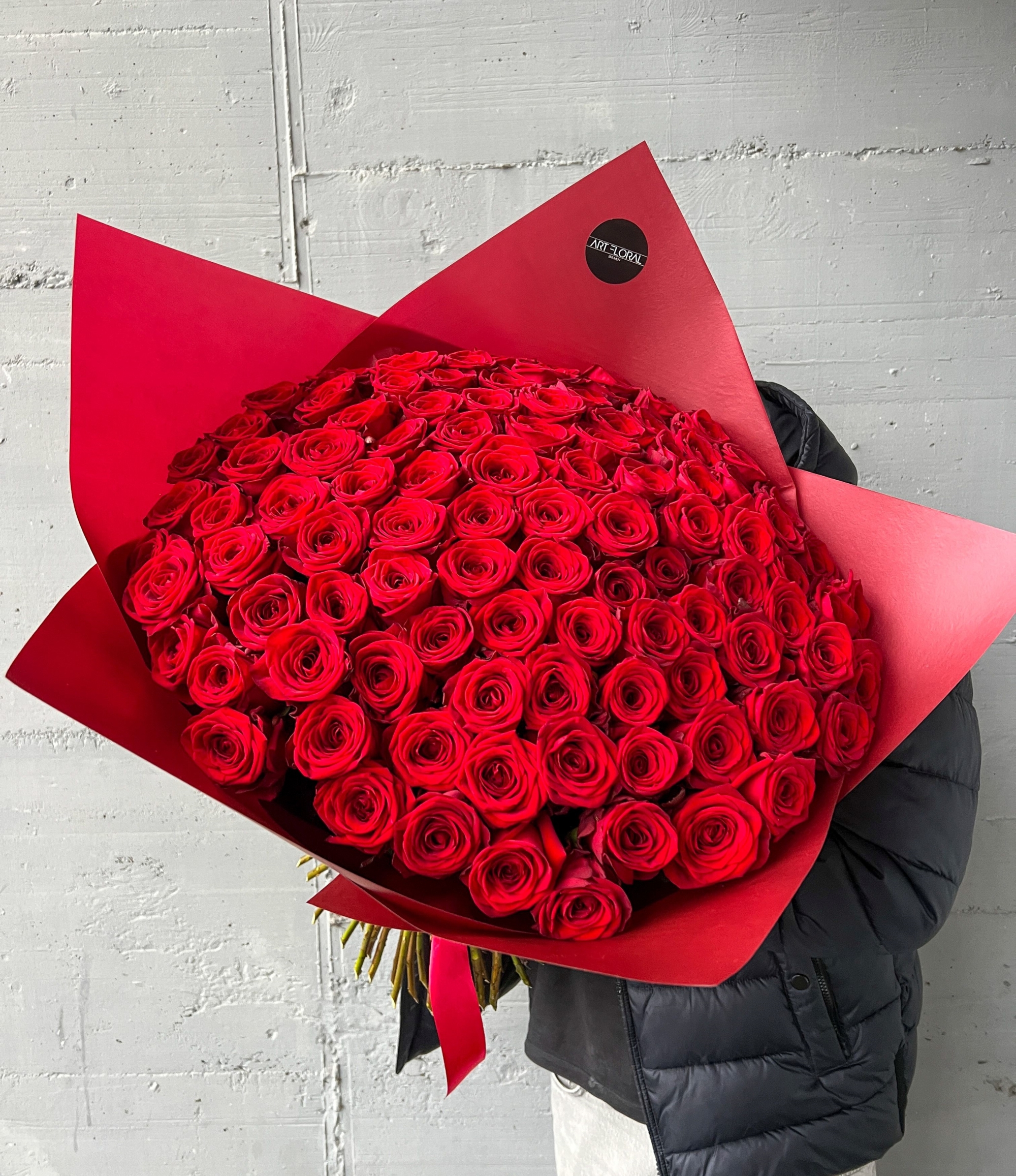 100 rote Rosen in roter Verpackung als großer Blumenstrauß