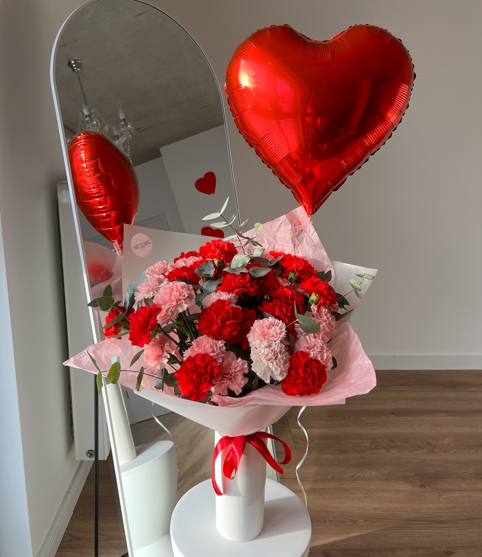 Blumenstrauß „Herzensfarben“ und rotem Herzballon – rosa und rote Nelken mit Eukalyptus