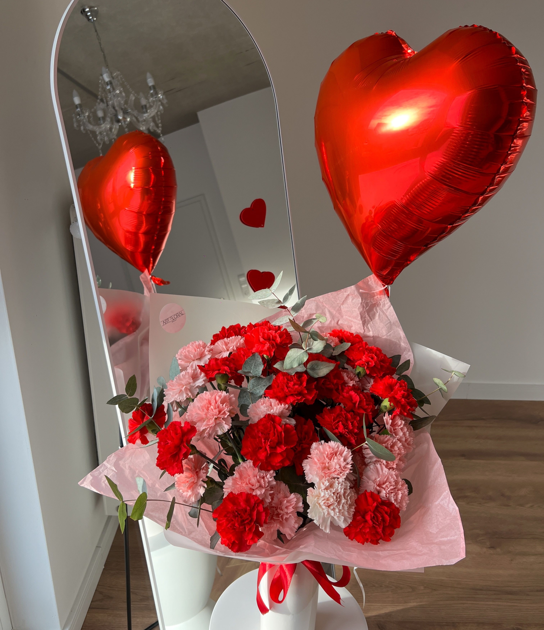 Blumenstrauß „Herzensfarben“ und rotem Herzballon – rosa und rote Nelken mit Eukalyptus