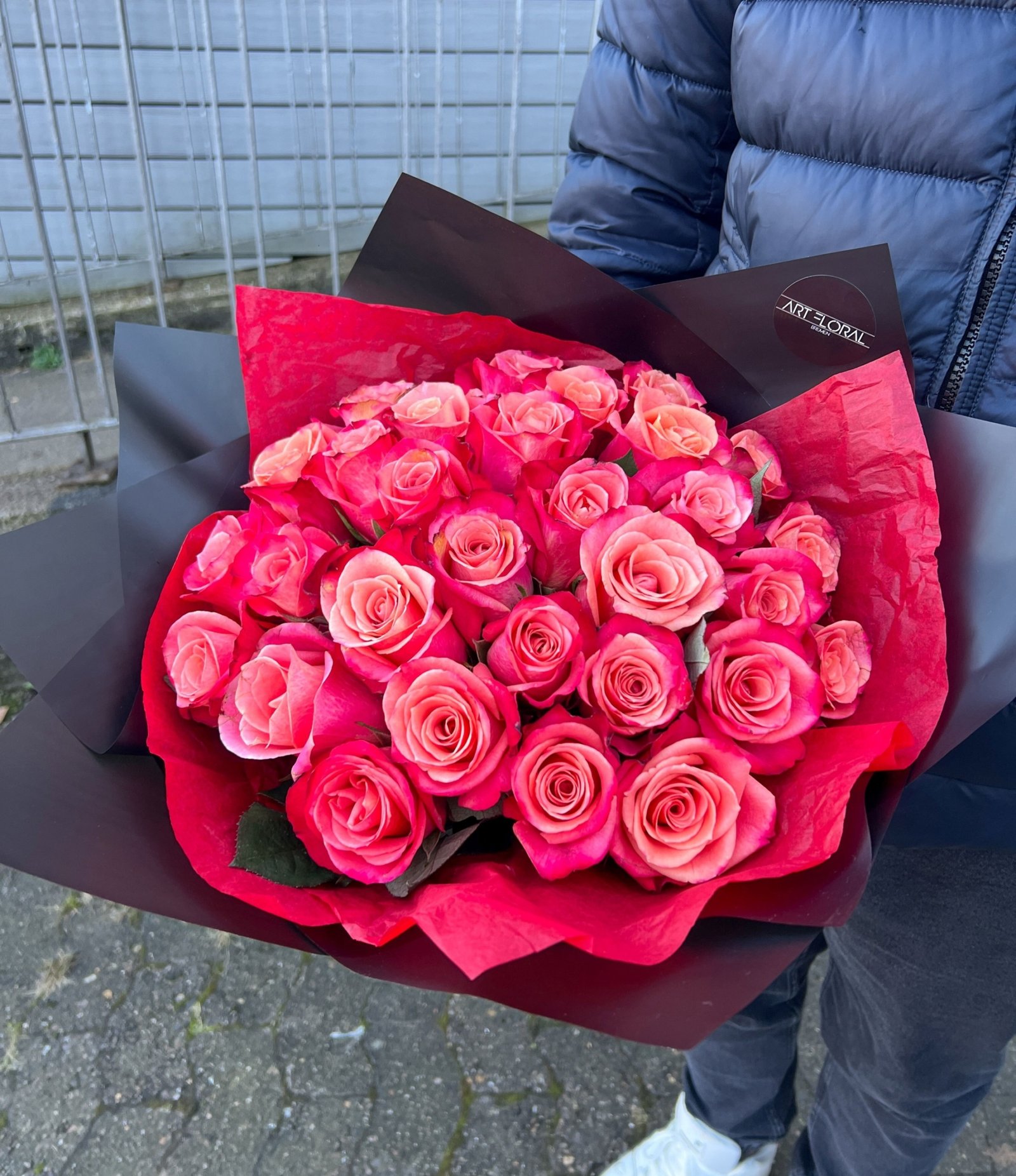 Blumenstrauß Urban Sunset mit rot-pinken Rosen in schwarzer Verpackung