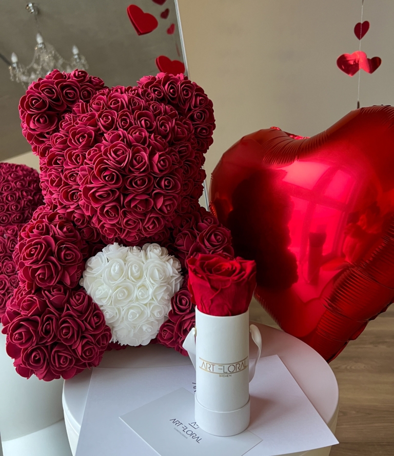 Geschenkset Bordeaux Love Bordeauxfarbener Rosenbär mit weißem Herz neben weißer Box mit Ewiger Rose und rotem Herzballon