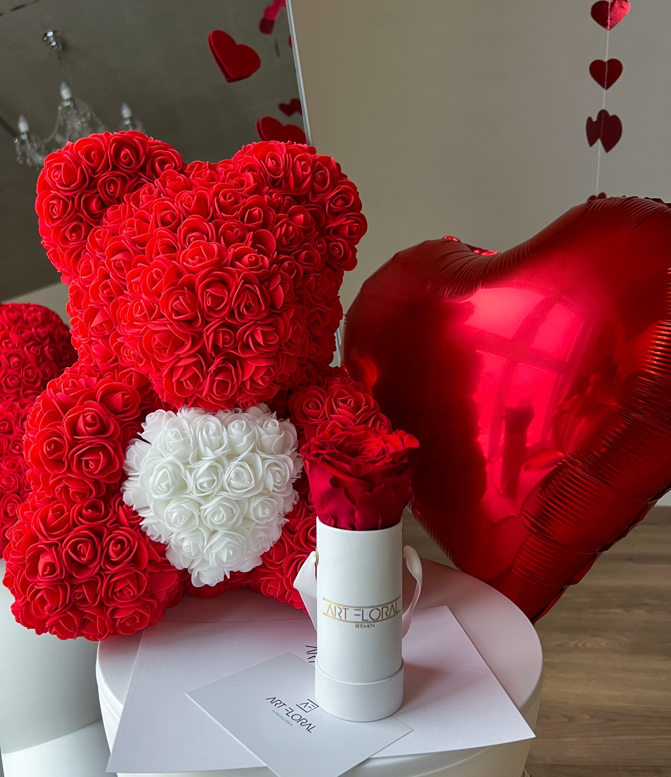 Geschenkset Red Love Roter Rosenbär mit weißem Herz neben weißer Mini-Box mit Ewiger Rose und rotem Herzballon
