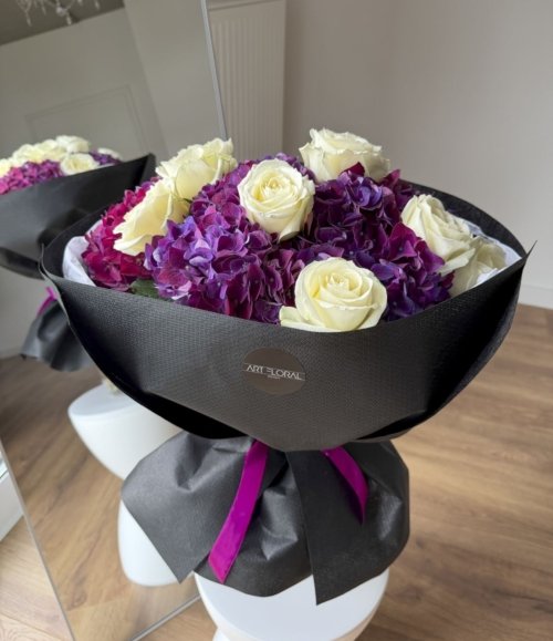 Eleganter Blumenstrauß mit lila Hortensie in schwarzer Verpackung
